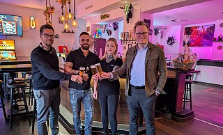 Alexander Menke (Stadtmarketing Büren), Alexander und Jana Vornweg sowie Michael Kubat (Wirtschaftsförderung der Stadt Büren) stoßen gemeinsam auf die Neueröffnung der Skull-Bar an. - Stadt Büren