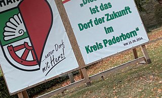 Auf der großen Tafel im Dorf, auf der die Überschrift der NW prangt, wird der Goldtitel von Scharmede gewürdigt. Nun kommt auch noch Silber auf Landesebene hinzu. - Jens Reddeker