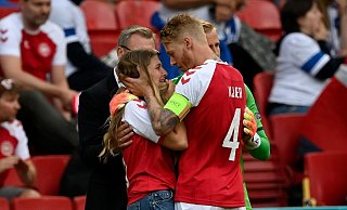 Tröstender Kapitän: Simon Kjaer (r) kümmert sich um die heraneilende Freundin von Christian Eriksen. - Foto: Stuart Franklin/Getty Pool/AP/dpa