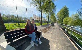 Celine und Maja genießen die Sonnenstrahlen auf der neuen Bank am Weserradweg. - Nicole Sielermann