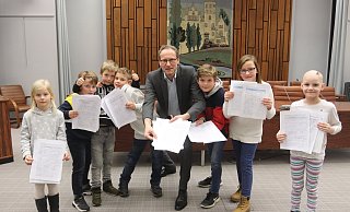 Die Kinder übergaben Bürgermeister Bernd Poggemöller 444 Unterschriften im großen Saal des Rathauses. - Dirk Windmöller