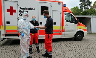 Leon Gamrath und Annika Nietschke helfen Philipp Berg in die Einweg-Sicherheitskleidung. Die Arbeit darin ist anstrengend. - Frank-Michael Kiel-Steinkamp