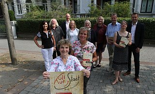 Astrid Menke (vorne l.) und Petra Müller zeigen Plakat und Programm. Im Hintergrund sind die weiteren Organisatoren zu sehen. - Nicole Sielermann