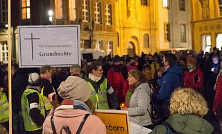 Einige Teilnehmer haben Kerzen oder Plakate dabei.  - Lena Henning