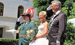 Gerhard Broer und Nadine Holzhauer-Broer versprühen gute Laune beim Parademarsch der Bökendorfer Schützen vor der Pfarrkirche. - Madita Schellenberg