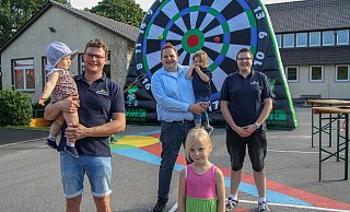 Der Vorstand der Büttendorfer Dorfgemeinschaft vor der Fußball-Dart Scheibe am Wahllokal "Grundschule": Marcel Schuster (l.) mit Tochter Tilda, Marco Knefelkamp mit Tochter Marie, Paula und Nils Knefelkamp. - Noah Brümmelhorst