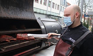 Vor dem Restaurant "Die Bank" räuchert Koch Felix in einem BBQ-Smoker aus den USA Fleisch für Pulled Pork Burger oder Barbeque-Ribs. - Björn Kenter