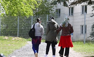 Asylbewerber gehen auf dem Gelände der Erstaufnahmeeinrichtung spazieren. - picture alliance/dpa