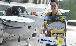 Rückkehr-Agenturleiterin Julia Handtke zeigt im Hangar des Höxteraner Flugplatzes, was drin ist in der Heimatbox. - Burkhard Battran