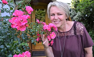 Bettina Hörster liebt die Natur und ihren Garten, in dem derzeit unter anderem die Rosen blühen. Im Hintergrund ist die Gartensauna zu sehen. - Karin Prignitz