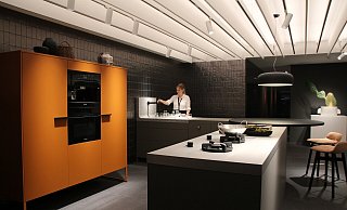 Während die Arbeitsplatte sowie die Koch- und Wasserstelle in puristischen Grautönen gehalten sind, leuchtet das Küchenmöbel in Terracotta förmlich. - Susanne Barth