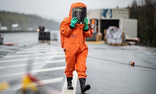Ein Feurerwehrmann geht in seinem ABC-Schutzanzug über die Autobahn in Bielefeld - im April war ein Speditionslastwagen umgekippt. Gefahrgut wurde vermutet, aber nicht gefunden. - picture alliance/dpa