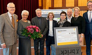 Dietmar und Margrit Harting (l.) sowie Philip Harting und Maresa Harting-Hertz (r.) überreichten den symbolischen Spendenscheck in Höhe von 150.000 Euro an Schulleiterin Marie-Luise Schellong (4.v.r.) und deren Vertreterin Ulrike Salge (4. v. l.) vom Söderblom-Gymnasium. Die Übergabe fand im Beisein von Espelkamps Bürgermeister Henning Vieker (3. v. r.) und Ralf H. Krause (3. v. l.), Oberkirchenrat und Finanzdezernent der Evangelischen Kirche von Westfalen, statt. - Harting