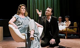 Karenin (Johannes Lehmann) nähert sich noch einmal seiner Frau Anna (Christina Huckle) an, die aber Wronski liebt. Im Hintergrund sitzen Lewin (Alexander Swoboda) und Kitty (Anna Schumacher), die gerade erst geheiratet haben. - FOTO: PHILIPP OTTENDÖRFER
