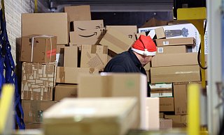 In einer Zustellbasis von DHL wird ein LKW mit Paketen entladen. - Bernd Wüstneck/dpa