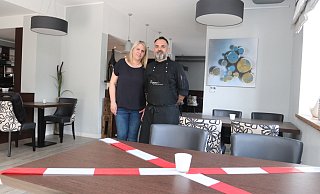 Marco und Tanja Lignante stehen im Restaurant Lignantes vor einem abgesperrten Tisch. Hier darf zu Corona-Zeiten niemand sitzen. Denn auch im Restaurant gilt: 1,5 Meter Abstand. - Dirk Windmöller