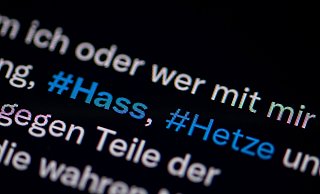 Auf dem Bildschirm eines Smartphones sieht man die Hashtags Hass und Hetze in einem Twitter-Post. - Fabian Sommer/dpa