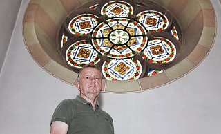 Auch das Rundfenster auf der Orgelempore, vor dem Kirchenvorstand Josef Hansjürgens steht, wird bei der Sanierung von Herz-Jesu einmal auf mögliche Beschädigungen hin kontrolliert und professionell vom Ruß gereinigt. - Thoering