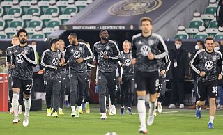 Die deutsche Mannschaft läuft zum Aufwärmen auf den Platz. - Foto: Christian Charisius/dpa
