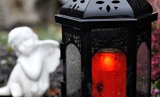 Ein Windlicht flackert, daneben sitzt ein kleiner Engel aus Porzellan. Die Polizei rät, einen Diebstahl auf einem Friedhof anzuzeigen. - Meiko Haselhorst