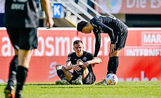 Filip Bilbija (l.), der hier im Heimspiel gegen Magdeburg angeschlagen auf dem Rasen sitzt, droht eine Zwangspause. - Besim Mazhiqi