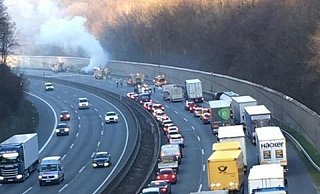 Das Fahrzeug brennt im Hintergrund auf dem Seitenstreifen, ein Löschzug bekämpft die Flammen, die Rettungsgasse der Verkehrsteilnehmer ist vorbildlich. - privat