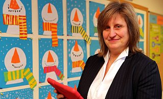 Petra Vogel-Deutsch, mit Tablet vor winterlichen Kunstwerken ihrer Schüler, leitet seit genau 212 Tagen den Grundschulverbund Wellensiek-Hoberge-Uerentrup. Digitalisierung ist ein Thema, um das sie sich zukünftig verstärkt kümmern will. - Wolfgang Rudolf