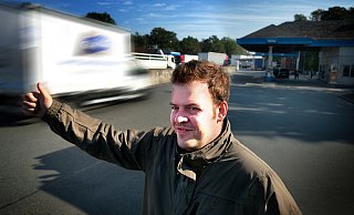 Morgens um zehn Uhr an der Autobahnraststätte: NW-Redakteur Max Maschmann möchte an der A 2 wissen, ob er spontan eine Mitfahrgelegenheit in einem anderen Auto finden würde. Der nach oben gereckte Daumen gehört natürlich dazu. - Andreas Frücht