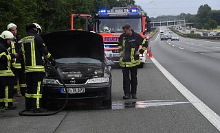 Einsatzkräfte des Löschzuges Spexard gehen gegen den Brand im Motorraum des Opel Vectra auf der Autobahn A 2 am Samstag mit Wasser vor. - Andreas Eickhoff