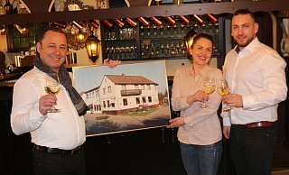Symeon Karachatzis (v. l.), Ardiana Kapuci und Stavros Karachatzis sind schonmal bereit, auf das 40-jährige Jubiläum des Restaurants Irodion anzustoßen. Sie halten ein Bild vom Irodion im Eröffnungsjahr 1981. - Anthea Moschner
