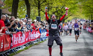 Gewinnen Sie ein Wanderer-Ticket für den Hermannslauf 2025 und freuen Sie sich wie hier Ingo Take, der 2024 mit der Wanderer-Startnummer 8247 den Zieleinlauf auf der Sparrenburg-Promenade in Bielefeld mit Clownerie feierte. - Sarah Jonek