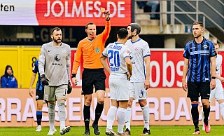 Schiedsrichter Martin Petersen zückt in der 27. Minute die Rote Karte für den Rostocker Lukas Scherff (Rückennummer 20). Nach Ansicht der TV-Bilder hatte der Referee auf Notbremse entschieden. - Besim Mazhiqi