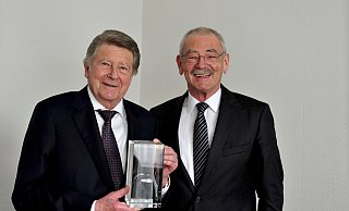 Neben einer Urkunde zur Ehrenbürgerschaft überreichte Bürgermeister Ernst-Wilhelm Vortmeyer eine Glasstatue mit einer 3-D-Darstellung des Rödinghauser Wahrzeichens Nonnenstein an Horst Finkemeier. - Gemeinde Rödinghausen