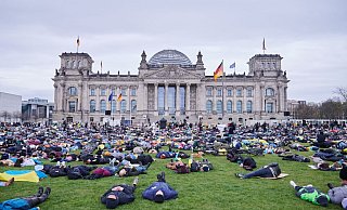 Liegender Protest vor dem Reichstagsgebäude in Berlin. - Foto: Annette Riedl/dpa