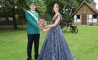 König Marvin Kröning und Regentin Lena Hamschmidt präsentieren sich beim Schützenfest in Sudhagen vor der Kulisse des Bauernhof-Ensembles „Gastliches Dorf“. - Regina Brucksch