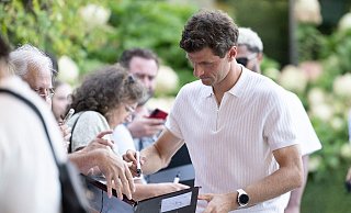 Thomas Müller machte die wartenden Fans am DFB-Teamhotel in Wolfsburg mit Autogrammen glücklich. - Swen Pförtner/dpa