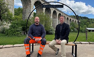 Christopher Dütting (l.) vom Bauhof und Bürgermeister Matthias Möllers testen die neue Bank unter dem Viadukt. - Gemeinde Altenbeken