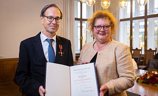 Bürgermeisterin Christina Osei überreicht Andreas Zick die von Bundespräsident Frank-Walter Steinmeier unterzeichnete Verleihungsurkunde. - Mike-Dennis Müller Bürgermeisterin Christina Osei überreicht Andreas Zick die von Bundespräsident Frank-Walter Steinmeier unterzeichnete Verleihungsurkunde. - Mike-Dennis Müller