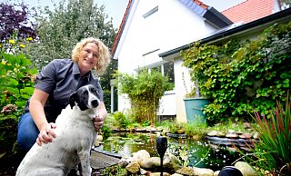 Das politische Engagement blüht: Gitte Trostmann zusammen mit ihrer Hündin Mika in ihrem Garten, wo sie Kraft für den Wahlkampf in Gütersloh schöpft. - Andreas Frücht