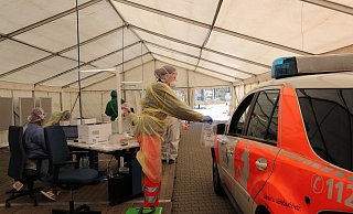 So funktionierts: Der Ärztliche Leiter des Rettungsdienstes, Dr. Thomas Jakob, ist mit seinem Dienstwagen ins Zelt gefahren und bekommt das Testset überreicht. - Frank-Michael Kiel-Steinkamp