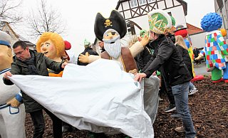 Bürgermeister Carsten Torke (l.) und StKG-Präsident Axel Remmert-Bobe packen beim Enthüllen der Figuren mit an. - Madita Schellenberg