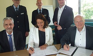 Investor Joachim Heda (v. l.), Landrätin Anna-Katharina Bölling und Investor Eckhard Witthake unterzeichneten jetzt den Vertrag für die neue Polizeiwache in Espelkamp. Interessierte Beobachter sind dabei Wachleiter Sven-Otto Deubel (hinten v. l.), Polizeidirektor Mathias Schmidt und Bürgermeister Henning Vieker. - Karsten Schulz