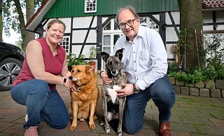 In grüner Idylle: Matthias Trepper mit Ehefrau Ann Katrin Brambrink sowie den beiden Hunden Toto (l.) und Emmie vor seinem Fachwerkhaus in Pavenstädt. - Andreas Frücht