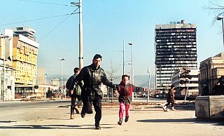 Szene aus dem Jahr 1994: Ein Einwohner Sarajvos rennt mit seinem kleinen Sohn an der Hand über die Straße, um sich in Sicherheit vor Heckenschützen zu bringen. - picture alliance / epa Ch.Simon/epa/dpa