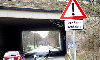 Verkehrsschilder weisen auf die Straßenschäden hin. Die Hiddenhauser Straße in Kirchlengern soll eine neue Fahrbahndecke bekommen. - Niklas Krämer
