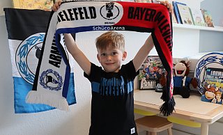 Als leidenschaftlicher Arminia-Fan ist Mario Thomulka bestens mit Fan-Artikeln ausgestattet. Den Schal zum siegreichen Halbfinale gegen Leverkusen hat er sich im Fanshop ausgesucht. - Shannon-Lee Bendig