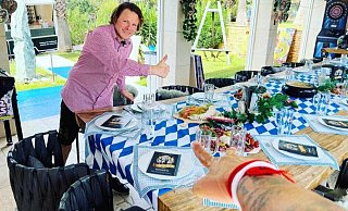 Denis Mann an der blau-weiß gedeckten Oktoberfesttafel. - Franco Bruno