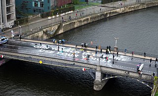Klimaaktivisten der Bewegung Fridays for Future malen auf der Marschallbrücke in Berlin den Schriftzug «Our world is on fire - use your voice!». - Christophe Gateau/dpa