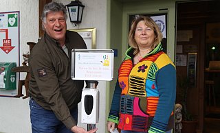 Einfach die Handfläche unter den Spender halten: Jan-Dirk Jungvogel zeigt im Eingangsbereich des Gestringer Hofs, wie die Gäste kontaktlos ihre Hände desinfizieren können. - Klaus Frensing