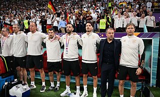 Bundestrainer Hansi Flick (2.v.r.) lauscht mit seinem Trainer- und Betreuerstab bei der Nationalhymne. - Federico Gambarini/dpa